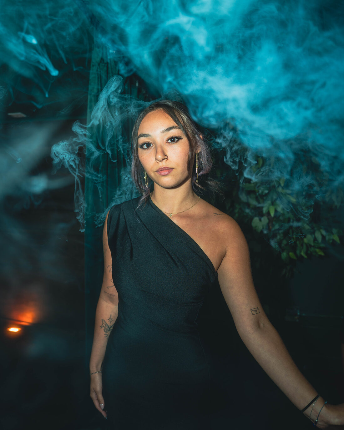 Flair bartender portrait in dramatic teal smoke