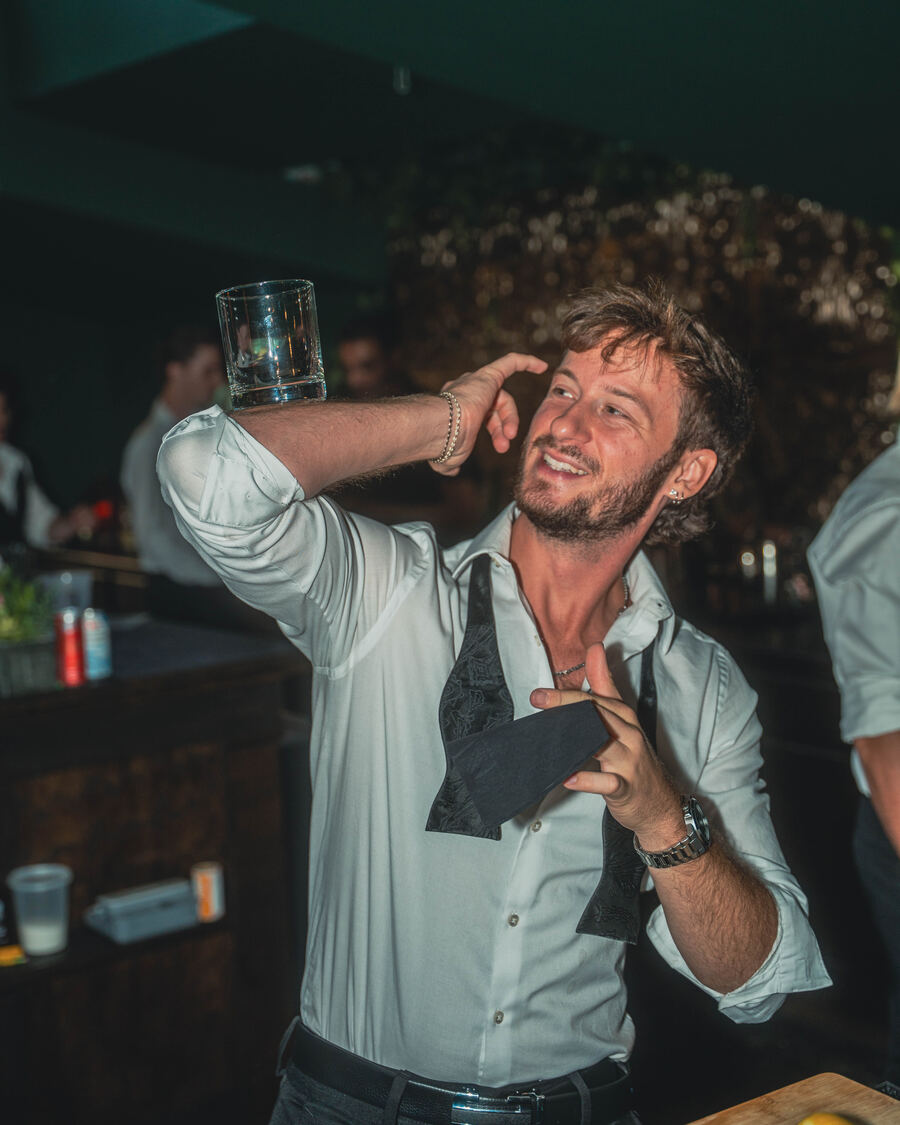 Flair bartender balancing a glass trick at a private party