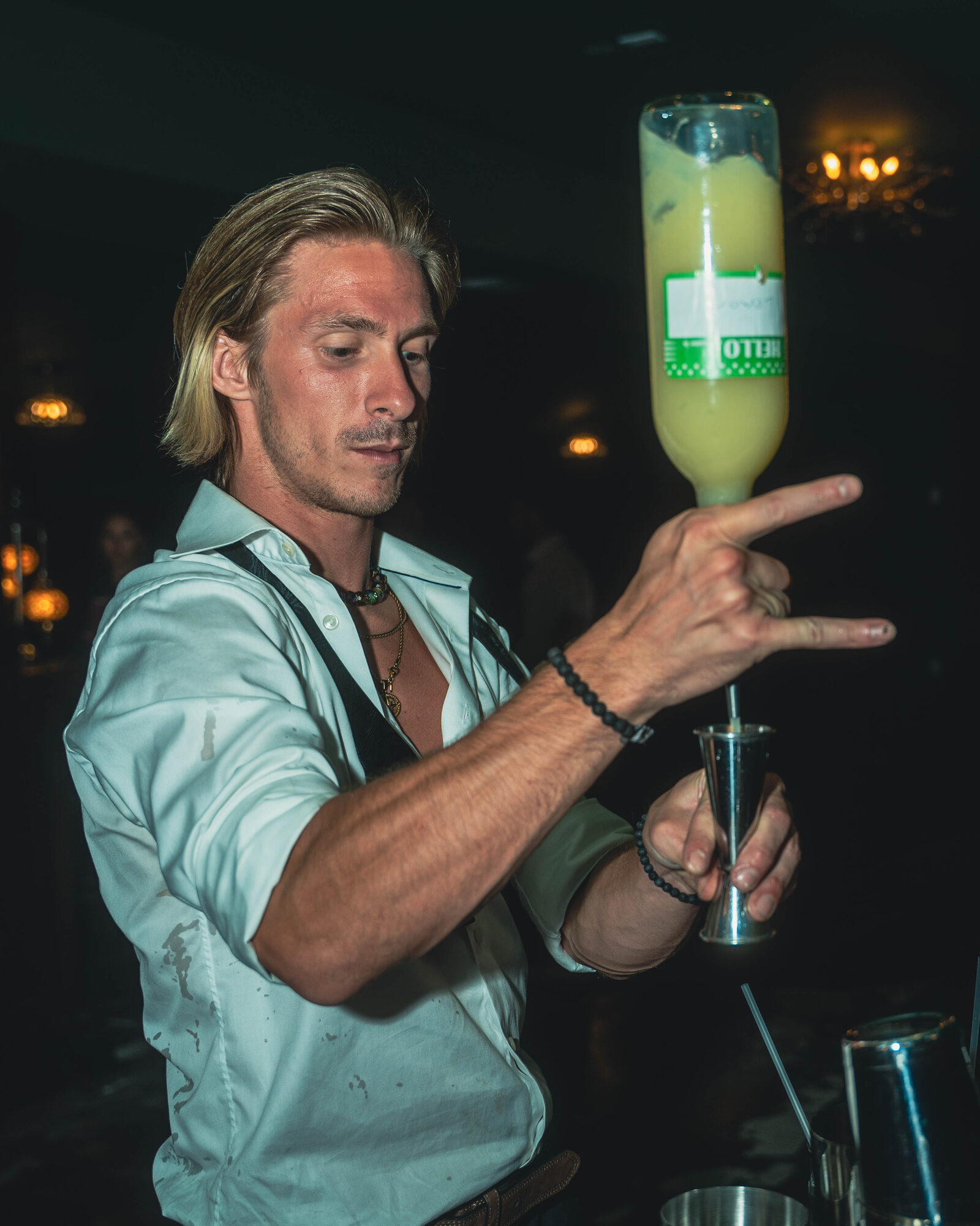 Flair bartender performing a bottle-pour trick at a wedding